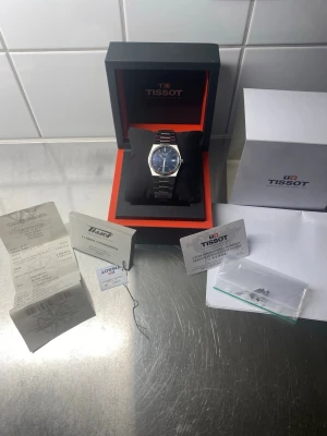 Tissot prx Powermatic 80 blå urtavla full set  - Säljer nu min mycket fina Tissot PRX Powermatic 80 i den populära 40 mm-versionen med blå urtavla. Klockan är en klassiker med en design som fungerar till det mesta.   Klockan är uttagen 2023 och fungerar utmärkt med det pålitliga powermatic 80 urverket. Den är i väldigt gott använt skick med normala mindre bruksspår som inte går att undvika vid vardagligt bruk. Klockan levereras full set med alla dess tillbehör som kvitto och försäkringsbevis som bilderna visar. Hör av er vid frågor!