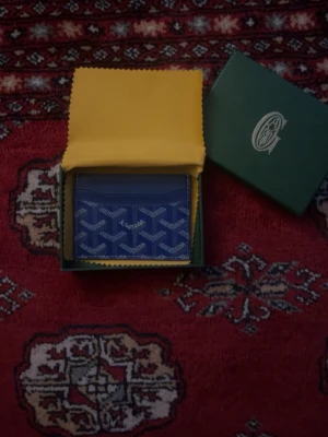 Blå korthållare - Snygg blå korthållare. Plånboken har flera fack för kort och är tillverkad i läder med canvasdetaljer. Perfekt för dig som vill ha en stilren och exklusiv accessoar.