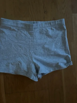 Grå shorts  - Ett par enkla och bekväma grå shorts,  i mjukt material. De har en midwaist passform och är perfekta för avslappnade dagar. Shortsen är enfärgade och har en klassisk, rak design utan extra detaljer.