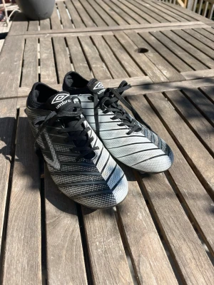 Svarta och vita Umbro fotbollsskor - Feta retroskor från Umbro i vit och svart. Unik design! Pris går att diskuteras. Bara använda några gånger!  😊(strlk 42 med är lite små i storleken) 
