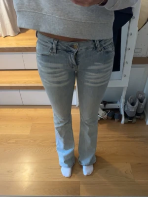 Ljusblå bootcut jeans - Säljer ett par ljusblå bootcut jeans. Jeansen har låg midja och är tillverkade i stretchigt denimtyg för skön passform. Perfekta för en avslappnad och trendig look.