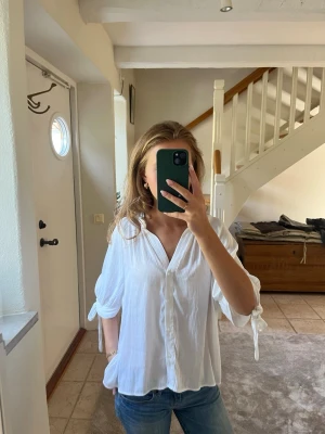 Vit blus  - Super fin och elegant blus med snörning i ärmarna 