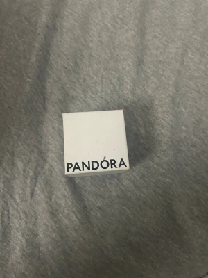 Pandora silverring med hjärta - Snygg silverring från Pandora med ett glittrande hjärta i mitten. Ringen har små stenar längs bandet och hjärtat är dekorerat med gnistrande stenar för extra bling. Perfekt för dig som gillar stilrena och romantiska smycken.