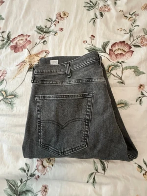 Levis jeans ”straight” - Säljer ett par grå jeans med rak passform och hög midja. Jeansen har klassiska bakfickor och bälteshällor. Materialet är denim i bomull och färgen är en snygg tvättad grå som passar till det mesta. Perfekta för en avslappnad och trendig look.  W38,L30 storlek