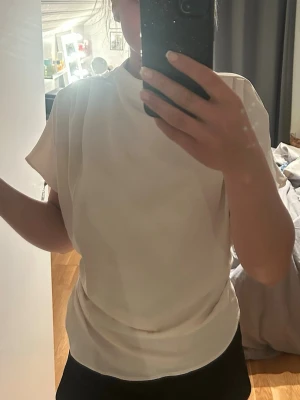 Vit kortärmad blus med lös passform - Säljer en stilren vit blus med korta ärmar och rund hals. Blusen är från Hm och är använd en gång.  lite genomskinlig, strl S