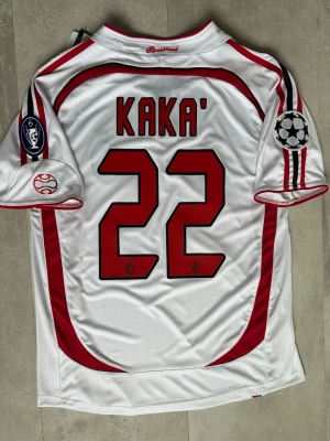 AC Milan Kaka fotbollströja - Säljer en helt ny vit AC Milan matchtröja från Adidas med Kaka och nummer 22 på ryggen.  Perfekt för dig som älskar fotboll och vill ha en ikonisk fotbollströja. Passar även dig som har storlek M. 