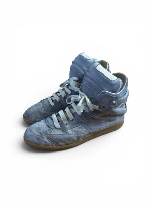 Maison Margiela SS10 high-tops - Maison Martin Margiela Spring/Summer 2010 Line 22 high tops/D-ring high tops i storlek 46 EU. Personligen har jag storlek 44 och jag satte bara in en extra sula och de passar perfekt, om behov finns kan jag skicka med extra sulor. Ett ganska gammalt par så de är ganska använda. Skavanker är: små delar av sulan på baksidan har tagits bort (som syns på bilderna), resten av skavankerna syns på bilderna. Tyvärr ingen låda men kommer skicka i en annan! Skriv i DM om intresserad!