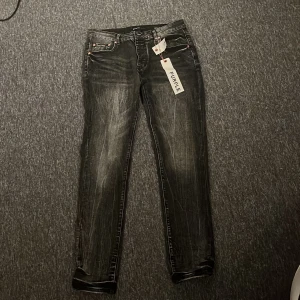 Svarta purple brand jeans - Säljer ett par svarta jeans med slitningar och tvättade detaljer. Jeansen har fem fickor, normal midja och raka ben. Materialet är klassisk denim med stretch för extra komfort. Perfekta för en avslappnad och trendig look. Jeansen är helt nya. Hör av er vid frågor 