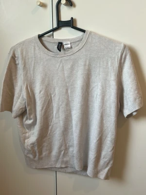 Ljusbeige kortärmad topp från H&M - Stockholm 📍 | Endast upphämtning 🤍En enkel och stilren ljusbeige topp från H&M med rund halsringning och korta ärmar. Tillverkad i mjukt material som känns skönt mot huden. Perfekt att matcha med jeans eller kjol för en clean look.