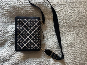 Trendig Malene Birger handväska - Snygg svart axelväska med vitt rutmönster och justerbar bred axelrem. Väskan har rektangulär form och guldfärgade metalldetaljer. Perfekt för dig som vill ha en stilren och trendig accessoar till din outfit.