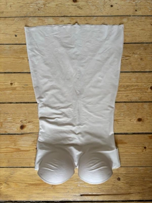 Beige shapewear klänning från H&M storlek 36, oanvänd  - Säljer en beige shapewear klänning med inbyggda kupor och slät, stretchig passform från H&M storlek 36. Klänningen har en sömlös design och justerbar knäppning i ryggen för extra komfort. Perfekt under tighta klänningar för en smickrande siluett. Oanvänd!