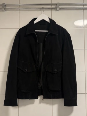 Massimo Dutti skinnjacka – 100% Goat Leather -Str M  - Stilren svart skinnjacka från Massimo Dutti i 100% äkta getskinn (goat leather). Mjukt och exklusivt läder med snygg klassisk passform. Mycket fint skick.  • Storlek M • 100% äkta getskinn • Nypris ca  -3500 kr • Modell 3319  Perfekt som höst-/vårjacka. Tidlös premiumjacka som passar till det mesta.