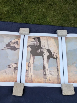 Tredelat canvastryck med Star Wars-motiv (AT-AT Walkers) - Säljer ett snyggt och oanvänt tredelat canvastryck med ett maffigt Star Wars-motiv (AT-AT Walkers). Setet består av tre separata dukar med fin struktur där varje del mäter ca 50x70 cm, vilket ger en total bredd på ca 150 cm på väggen.  De är oramade och har en vit marginal runt om, vilket gör att de passar perfekt i vanliga 50x70-ramar (t.ex. från IKEA) eller för att spännas upp på kilramar.  Riktigt häftig inredningsdetalj till spelrumme