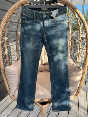 Jeans strl. 40 - Blå jeans från Review med raka ben och klassisk femficksmodell. Jeansen har slitningar och kontrastsömmar för en trendig look. Tillverkade i denim med en skön passform. 