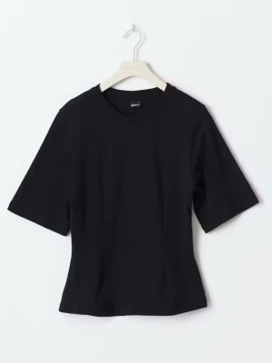 Svart figursydd t-shirt med kort ärm - En stilren svart t-shirt med klassisk rund hals och korta ärmar. Tillverkad i mjuk bomull som känns skön mot huden. Perfekt att matcha med jeans eller kjol för en clean look.