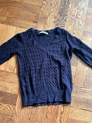 Mörkblå tröja från zara - Mörkblå stickad tröja från zara med V-ringning och ett snyggt kabelstickat mönster. knappt använd och i superskick❣️🥹.