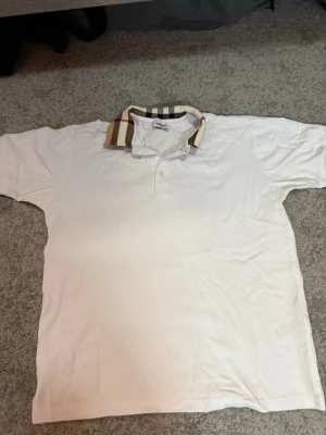 Burberry Piké Vit - Klassisk Burberry piké i vitt med stilren och tidlös design. Enkel att matcha och passar både casual och mer uppklädda outfits.  Färg: Vit Storlek: S  Fraktar inom 24h vid snabb affär. Byten är inte aktuella.  #Burberry #BurberryPolo #Piké #Menswear #LuxuryFashion