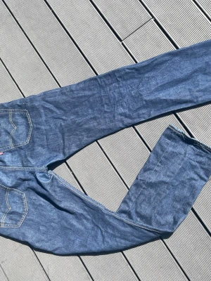 Levis 501  - Klassiska blå jeans i rak modell med kontrastsömmar och femficksdesign. Jeansen har normal midja och är tillverkade i denim. Perfekta för en avslappnad och tidlös stil. W33/L34