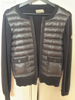 Svart cardiganjacka från Moncler - Jag säljer denna snygga svarta cardigan från moncler som är perfekt för båda våren, sommaren och hösten💕 den är i fint skick men bara lite hundhår på som syns på bild💞 men de tar jag förstås bort☺️ skriv vid minsta fundering