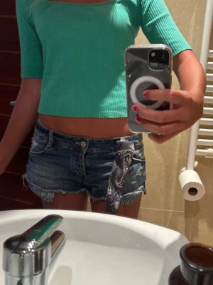 Snygga jeanshorts - Super coola och snygga jeanshorts med en cool ”scarf” detalj och fina mönster på framfickorna. Shortsen har en sliten look som är trendigt och snyggt. Tyget har ”kurvat” sig lite vilket inte märks när man har på sig dem men annars inga defekter.🩷