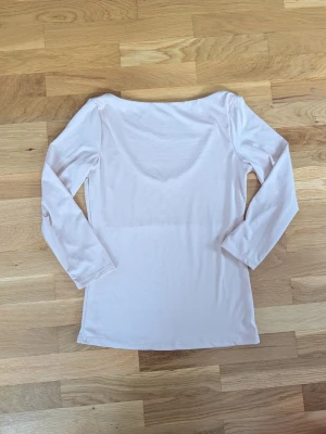 Ljusrosa långärmad topp - En enkel och stilren ljusrosa långärmad topp med rund halsringning. Tillverkad i ett mjukt och stretchigt material som känns skönt mot huden. Perfekt att matcha med jeans eller kjol för en clean look.