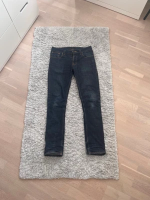 Mörkblå slim fit jeans - Nudie Jeans - Modell Grim Tim - Storlek W33 L34 - Mörkblå - Feta Fades - Nypris: ca 1699, nytt pris: 379kr!