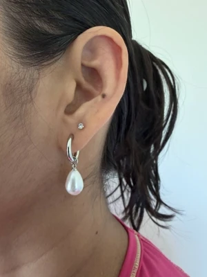 Silvriga örhängen med droppformade pärlor - Priset avser ett par örhängen och Matchande halsband finns i en separat annons. Finns även i guldfärgad variant.  • Material: Rostfritt stål och       ABS (Det står för Acrylonitrile             Butadiene Styrene) för pärlorna • Längd: ca 30 mm • Nickelfria och handgjorda