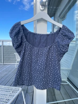 Söt blommig brandy Melville topp - Supersöt blå topp med små vita blommor och puffiga korta ärmar. Supermjuk och skön!