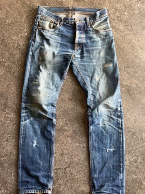 Nudie jeans steady Eddie extremely rare without packpocket embroidery from factory - Nudie jeans steady Eddie dry selvedge som använts i ett flertal år. De har inte någon backpocket embroidery vilket är meningen och är så ifrån fabrik vilket gör de extremt sällsynta.  Blivit lagade professionellt i fickor och på benen.   Storlek 29/32 men passar som 30/32 se mått nedan!  Midja: 41cm längd: 102cm lår: 23cm benöppning: 18cm   Fråga gärna frågor!