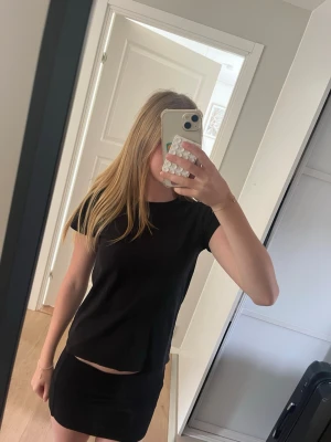 Svart t-shirt från H&M - En enkel svart t-shirt från H&M med rund halsringning och korta ärmar. Tillverkad i mjuk bomull som känns skön mot huden. Perfekt basplagg att matcha med allt i garderoben.