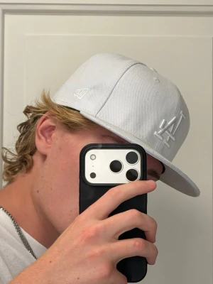 NEW ERA KEPS - Säljer en vit new era keps med broderad Los Angeles Dodgers logga. Kepsen är lite för stor för mig och har därför näst intill alldrig används.                            Pris går att diskuteras vid snabb och smidig affär!