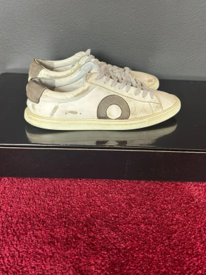 Vita Oliver Cabell sneakers med grå detaljer - Säljer ett par vita Oliver Cabell strlk 39 men passar 40. sneakers med grå mockadetaljer på häl och sidor