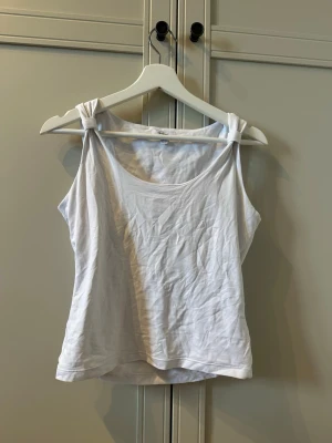 Vitt linne med knytdetaljer - Fint basic vitt linne i elastiskt material (liknar Zaras linnen!) men med extra knutdetaljer på axelbanden! Passar mig som är en S men storleken är ju M egentligen!