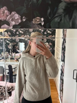 Beige stickad hoodie - Mysig beige stickad hoodie med avslappnad passform och långa ärmar. Tröjan har ribbade muddar vid ärmslut och nederkant samt en mjuk huva. 🌸