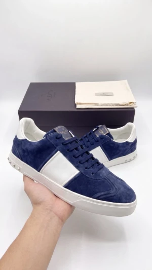 Blå och vita sneakers från Valentino - Snygga sneakers i blå mocka och vitt läder från Valentino. Skorna har vita detaljer, platta snören och coola nitar på hälen. Perfekta för dig som vill ha en stilren men ändå unik look. Kommer med originalkartong och dustbag.