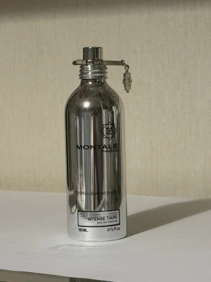Montale Intense Tiare Eau de Parfum - Montale Intense Tiare Eau de Parfum i en spegelblank, silverfärgad metallflaska med säkerhetslås. Flaskan rymmer 100 ml och har en modern, minimalistisk design med svart text och logotyp. Perfekt för dig som gillar exklusiva och unika dofter.