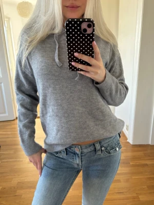 Grå stickad hoodie med huva - Jättefin grå stickad hoodie med huva och dragsnören. Tröjan har en avslappnad passform, är tillverkad i ett mjukt material. Aldrig använd💕 Skriv för mer info