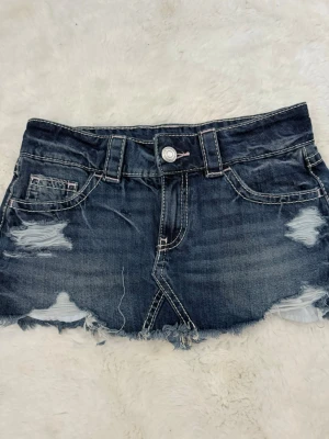 Jeans kjol  - Säljer en kort blå jeanskjol med slitna detaljer och rå kant ifrån Gina Tricot. Kjolen är endast använd en gång och är därav i väldigt fint skick. Väldigt populär kjol då den är slutsåld i de mesta butiker och helt online, strl XS ( skriv till mig ifall du är intresserad )