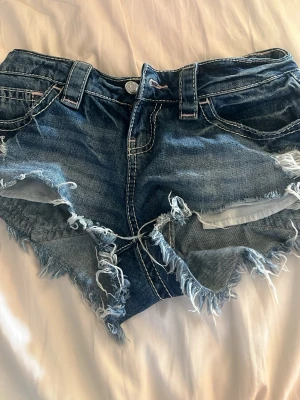 Blå slitna jeansshorts Gina Tricot - Säljer ett par super fina lågmidjade jeans shorts från Gina!💕