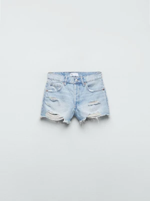 Ljusblåa midwaist jeansshorts - Säljer ett par ljusblåa jeansshorts med mid midja och slitna detaljer. Shortsen har råa kanter och flera revor framtill för en trendig, avslappnad look. Perfekta till sommaren och lätta att matcha med olika toppar.