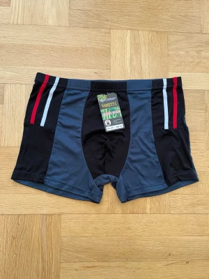 Vanetti kalsonger med bambufiber 3XL - Kalsonger i nyskick med etikett från Vanetti i storlek 3XL, tillverkade av mjuka bambufibrer. Färgen är en mix av svart och mörkblått med röda och ljusblå ränder på sidorna. Boxermodell med bekväm passform och elastisk midja. Bambu.