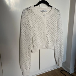 Vit stickad kofta med knappar - Säljer min superfina vita stickade/broderade kofta från NA-KD med knappar framtill. Använd vid 1 tillfälle