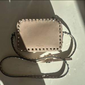 Säljer en superfin beige axelväska från Valentino i skinn med coola nitar runt kanterna. Väskan är i nytt skick och kommer med originalförpackning. Perfekt för både vardag och fest! 👜✨