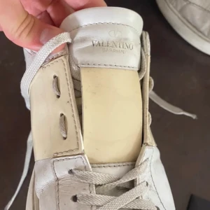 Valentino Garavani sneakers - Säljer ett par vita Valentino Garavani sneakers i skinn. De har en stilren design med snörning och är i bra skick. Perfekta för både vardag och festliga tillfällen. Kommer med originalförpackning.