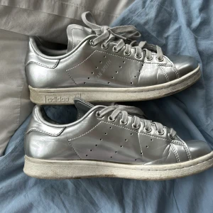 Silvriga Adidas Stan Smith sneakers - Säljer ett par coola silvriga Adidas Stan Smith sneakers i bra skick. använda fåtal gånger 