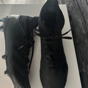 Svarta fotbollsskor med snörning - Säljer ett par svarta fotbollsskor i syntetmaterial. De har en tight passform och snörning för bästa komfort. Mycket fina skor använda knappt en halv säsong! 🤩🤩Pris kan disskuteras !!🩷🩷