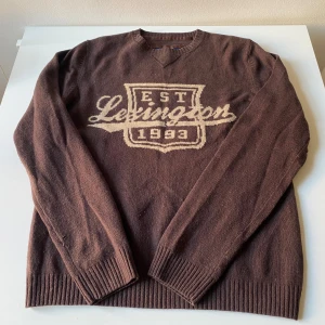 Brun tröja från Lexington - Säljer en brun tröja från Lexington med tryck framtill. Den är i bra skick och perfekt för höst och vinter. Tröjan har långa ärmar och ribbade muddar vid ärmslut och nederkant. Supermysig och stilren för kalla dagar!