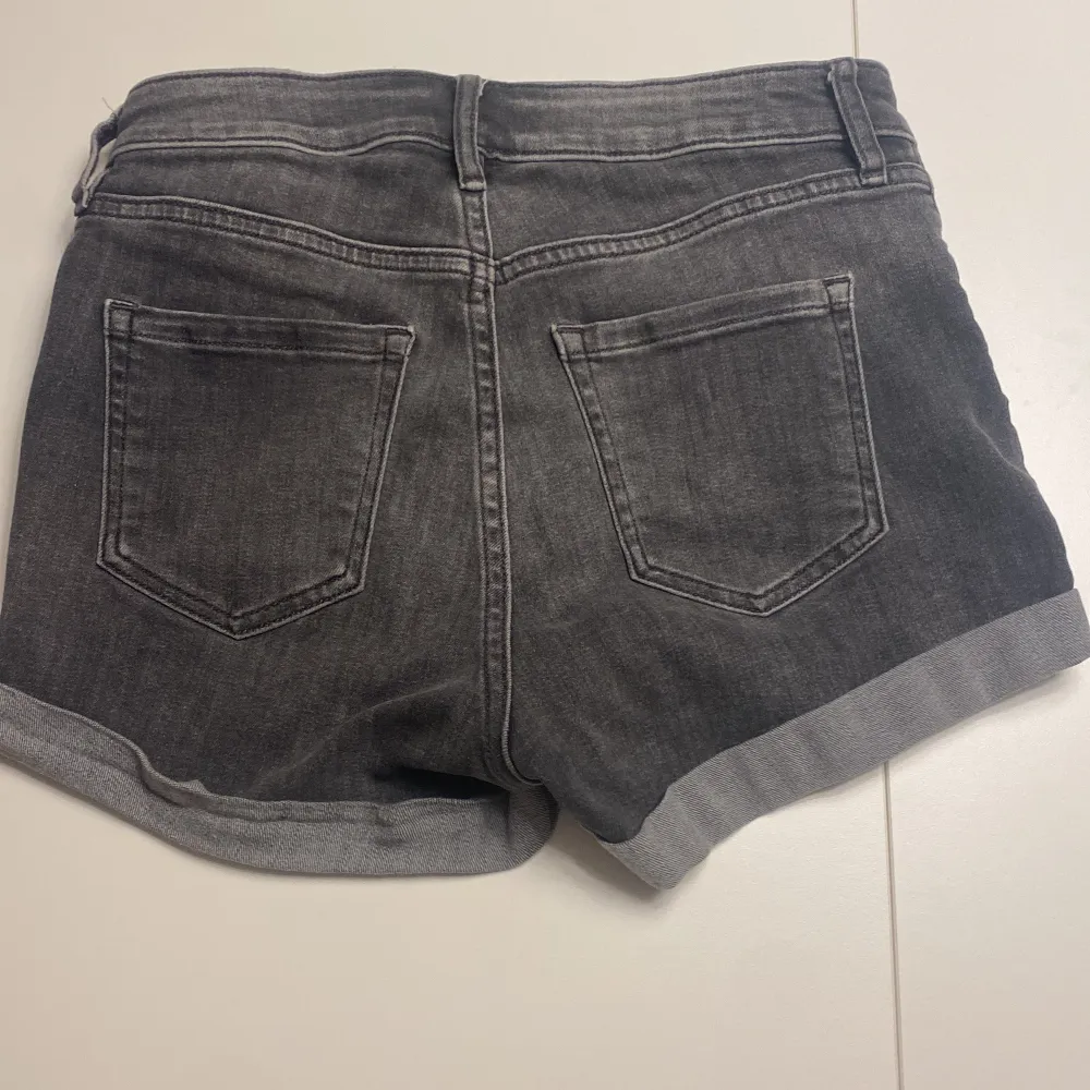 Säljer ett par svarta jeansshorts från H&M i storlek 34. De har en klassisk femficksdesign och är uppvikta vid benen för en avslappnad look. Perfekta för sommardagar eller festivaler! 🖤. Shorts.