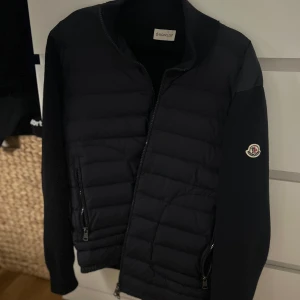 Moncler cardigan  - Säljer nu brosans gamla moncler cardigan då varken jag eller han vill/behöver den eftersom han har ”bytt” stil. Fin tröja/jacka som är lagom varm och ”trendig”. Vill helst bara bli av med den så antar att det är först till kvarn annars hamnar den nog i nån låda på vinden, den passar mig som är 180cm och den är i storlek L/3. Priset är inte hugget i sten heller så är öppen för prisförslag men helst rimliga, Även öppen för byten