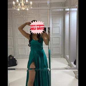 Turkos långklänning med slits - Säljer en fantastisk turkos långklänning med en elegant slits framtill. Använd 1 gång och finns inga skador! Klänningen har en vacker, djup färg och är perfekt för festliga tillfällen. Den är axelbandslös och har en smickrande passform som framhäver figuren. Perfekt för en kväll ute eller en speciell fest! Stolen s